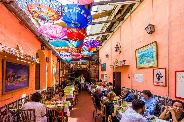 Ein argentinisches Restaurants mit bunten Schirmen an der Decke. Hier kannst du leben wie die Einheimischen auf deiner Südamerika Reise.