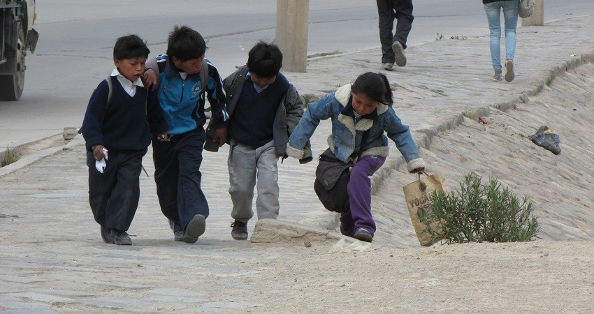 #viventurameets: Sozialprojekte in Bolivien. Vier Kinder Laufen Hand in Hand über die Straßen von Potosí.