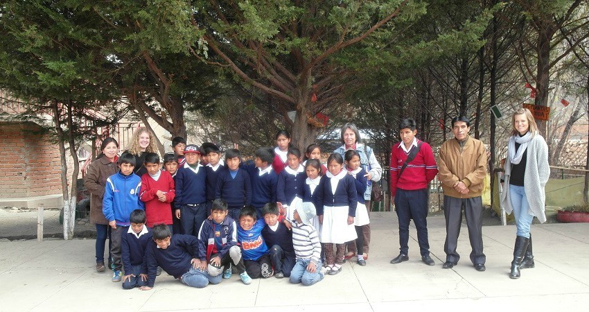 Kinderrechte in Bolivien: Auf dem Schulhof stellen wir uns zusammen mit dem Direktor und den Kindern für ein Gruppenfoto.