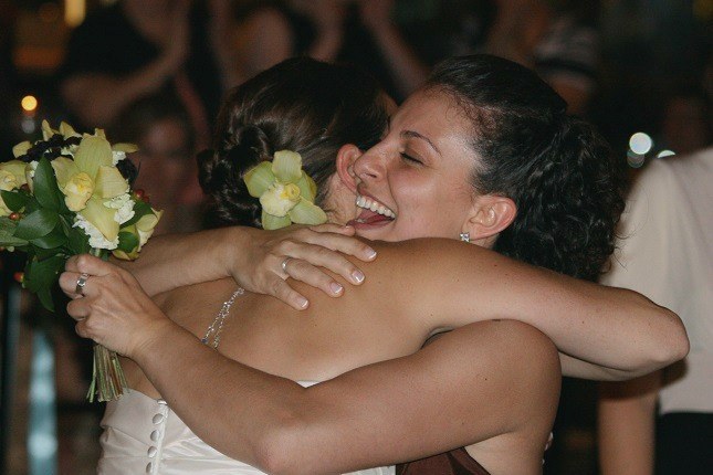 Zwei Freundinnen umarmen sich zur Begrüßung auf einer Hochzeit.