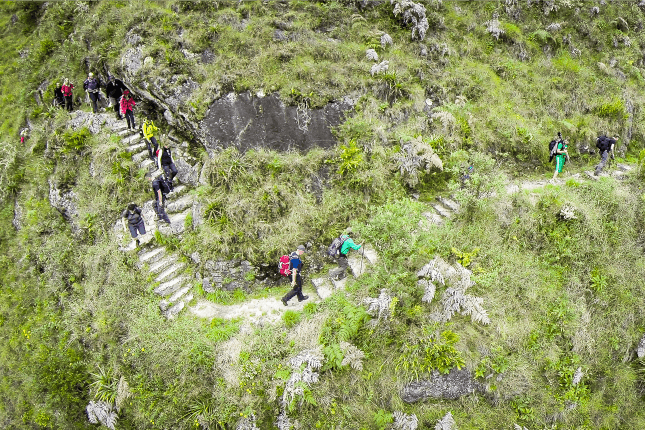Trekking in Peru: Ganz schön steil! Über viele Stufen gelangen Wanderer auf dem Inkatrail durch atemberaubendes Andenpanorama bis zur berühmten Inkastätte
